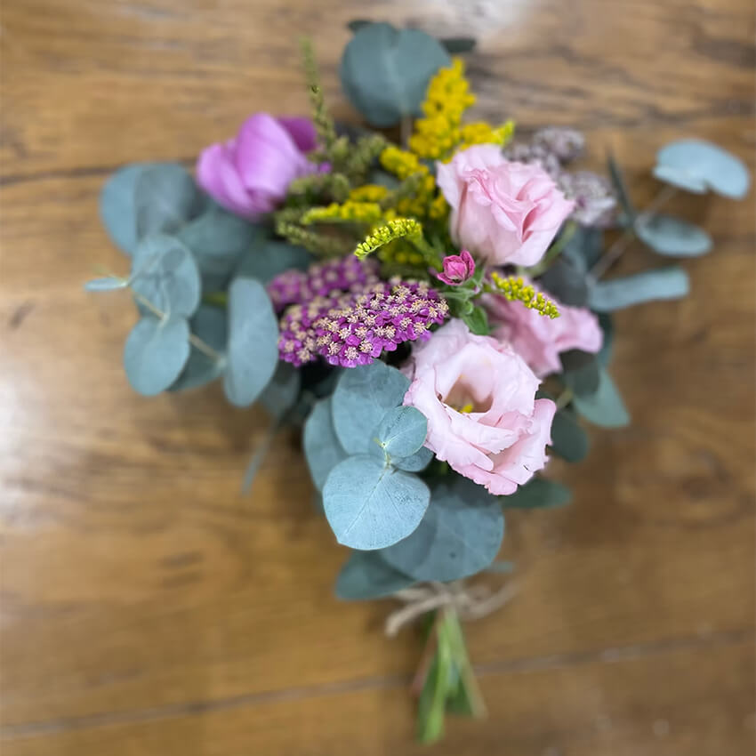 Small rustic posy of pink lisianthus, yellow solidago, magenta yarrow and silver dollar eucalyptus