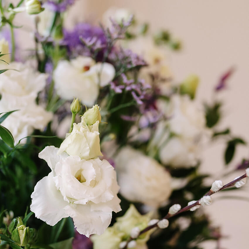 Close-up of a wedding table centrepiece with white roses, alliums and mixed greenery by The Flower Shed Westerleigh