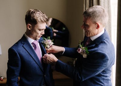 Two groomsmen in navy suits with floral buttonholes at a wedding, flowers by The Flower Shed Westerleigh